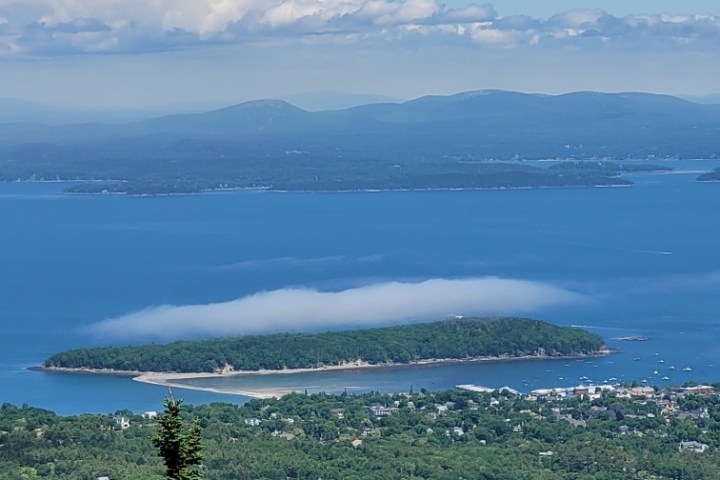 a large body of water with a mountain in the background